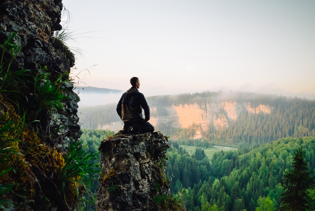 Man sitting on the top of the mountain in yoga